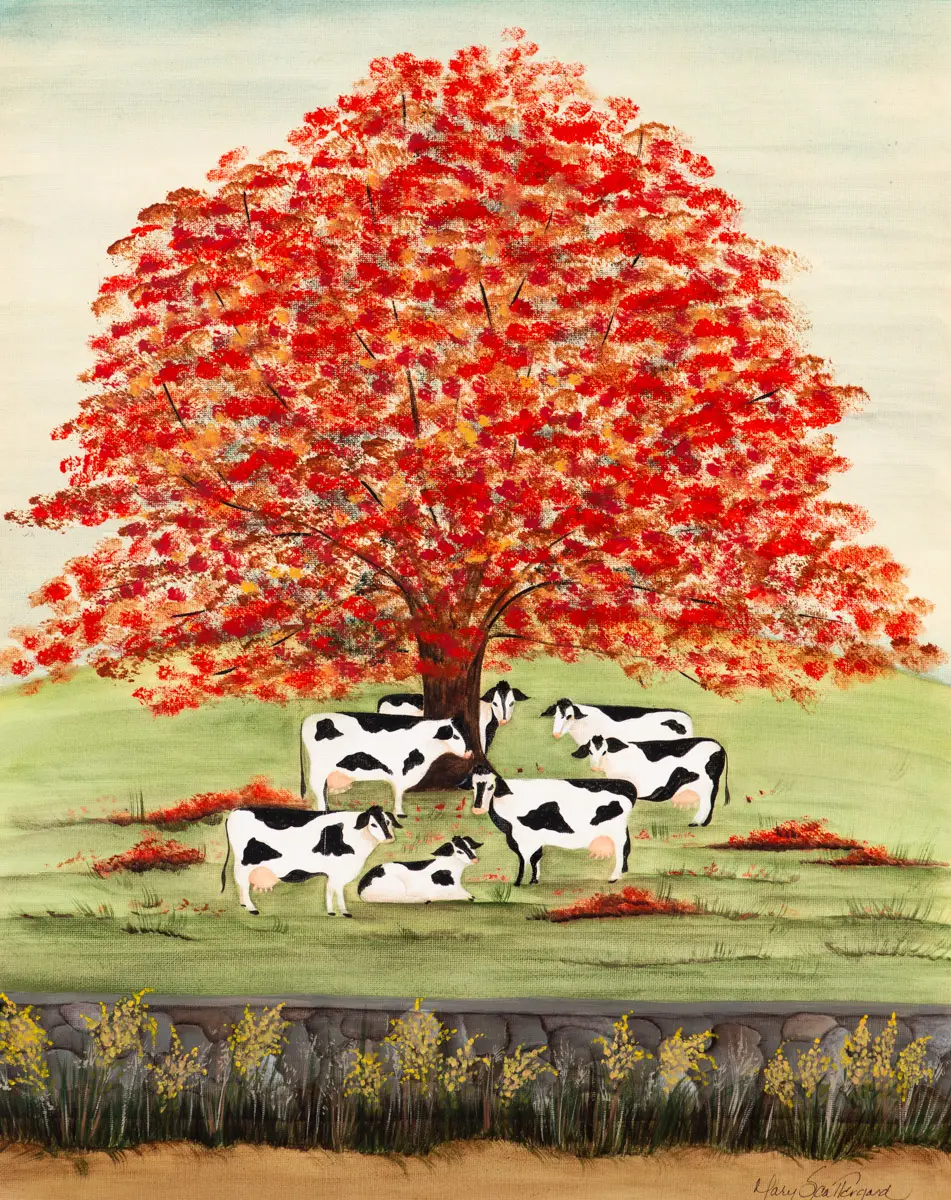 Cows under a vibrant red tree